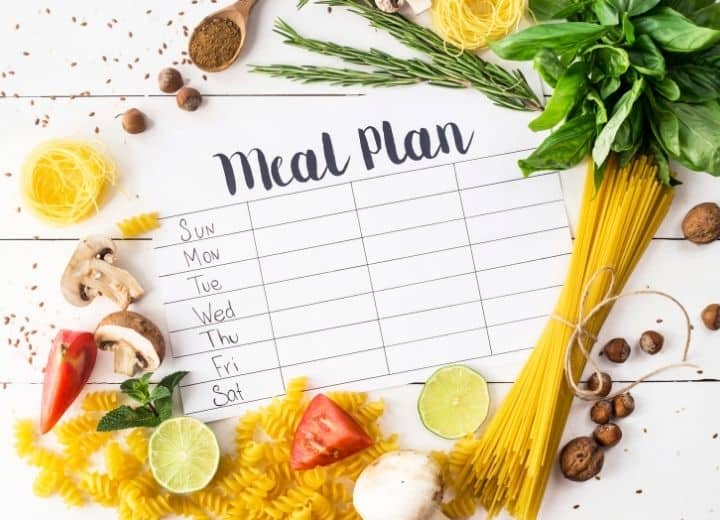 meal planning template surrounded by pasta, basil tomatoes, and mushrooms