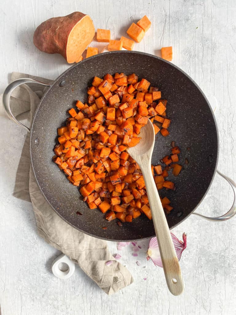 sweet potatoes, carrots and spices sauteeing in a pan