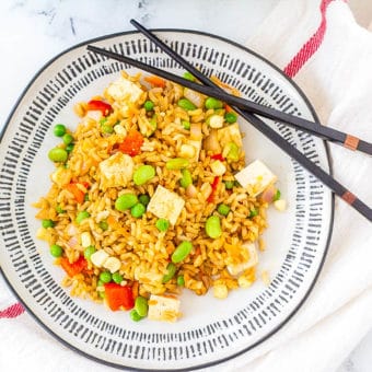 vegan tofu fried rice with vegetables, served on a white plate