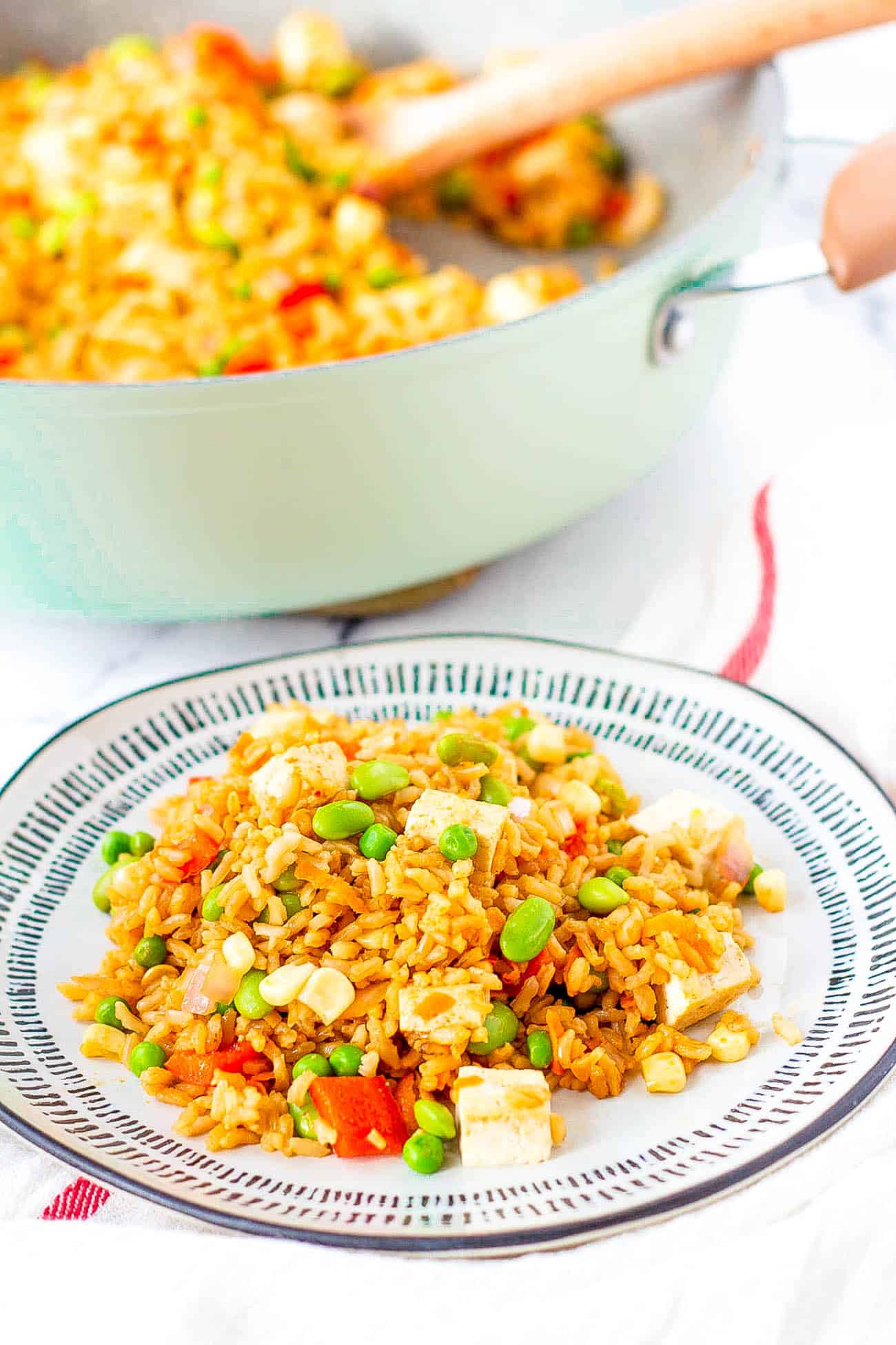 vegan tofu fried rice with vegetables, served on a white plate