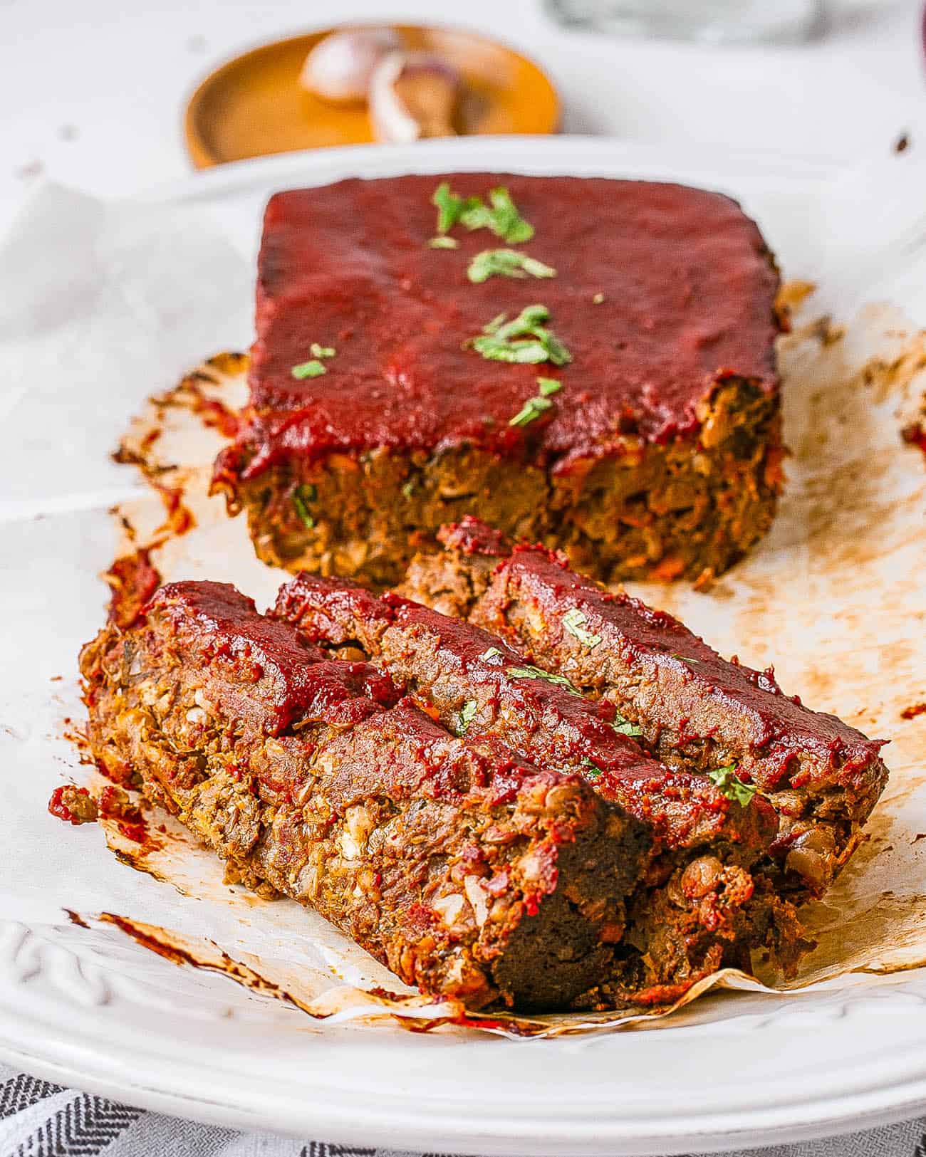 vegan lentil meatloaf / vegan lentil loaf with tomato glaze served on a white plate