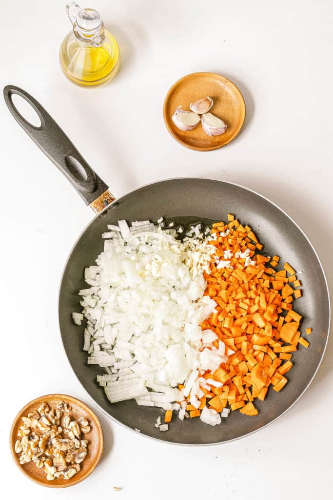 onions and carrots sauteeing in a pan