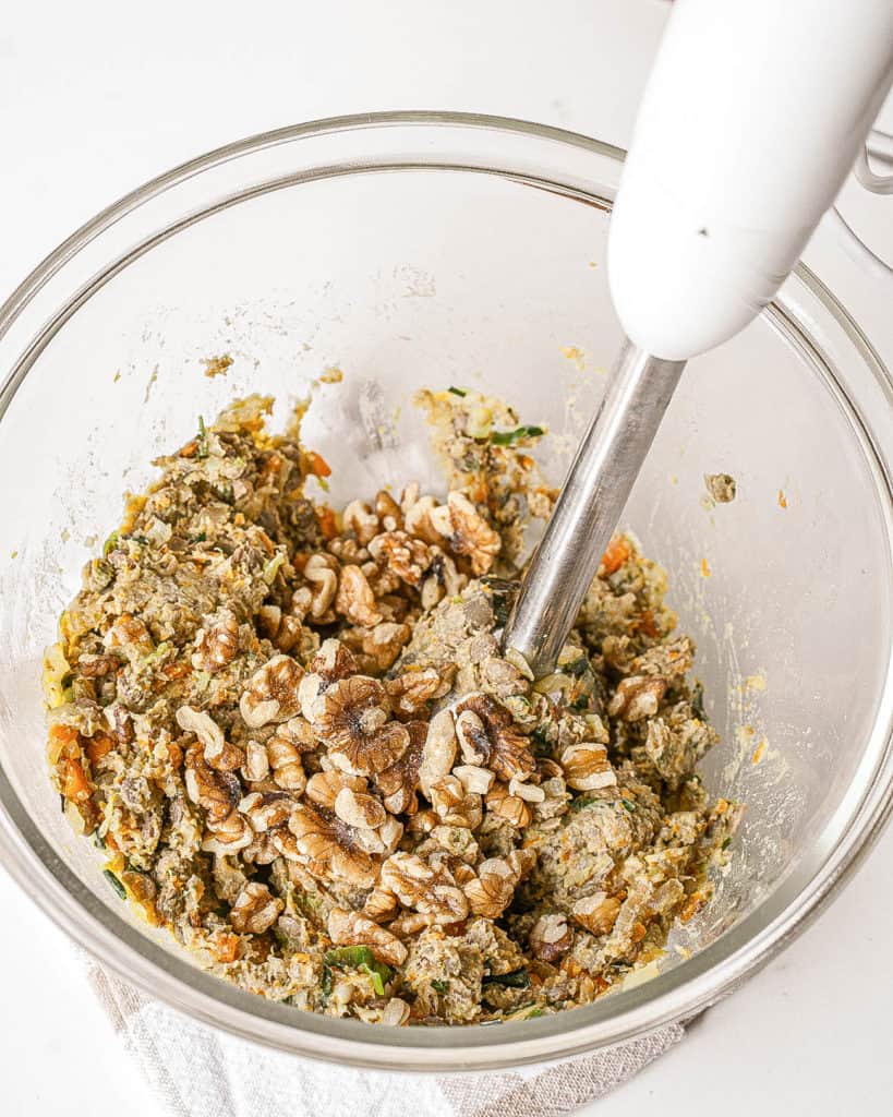 walnuts added to veggie mixture pureed in a bowl
