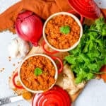 red lentil dahl served in red ramekins topped with cilantro