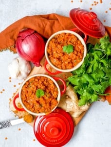 red lentil dahl served in red ramekins topped with cilantro
