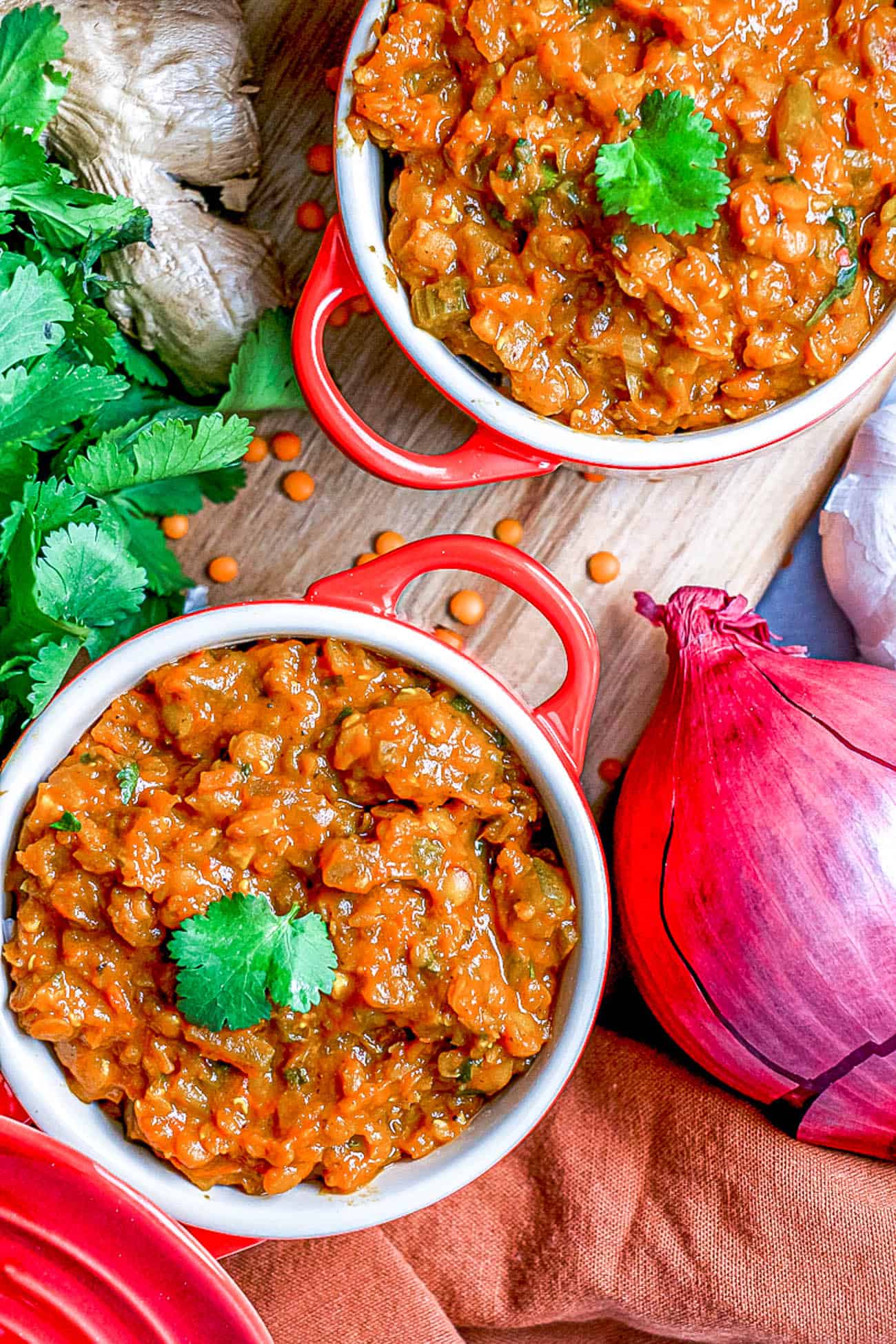 red lentil dahl served in red ramekins topped with cilantro