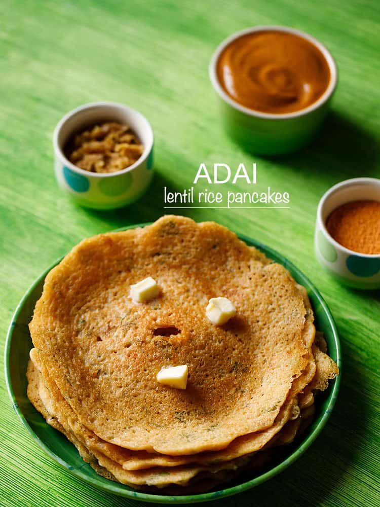 adai lentil pancakes stacked on top of one another on green background