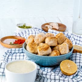 air fryer tofu in a blue bowl with spices and a napkin on the side, side view