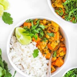 sweet potato and chickpea curry in a white bowl served with rice