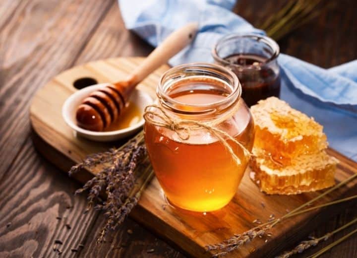 honey in jars served on wood tray - natural sugar vs. added sugar