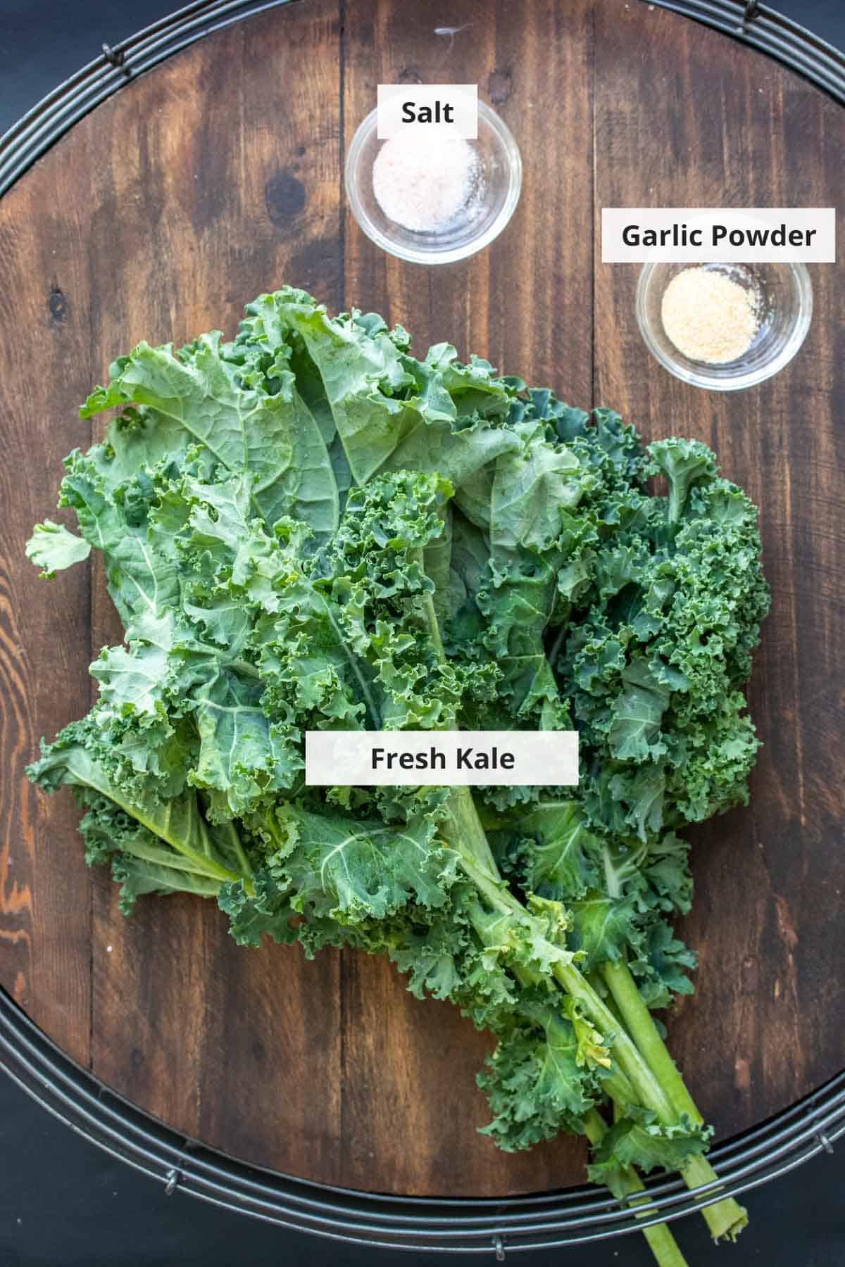 Ingredients for crispy baked kale chips on a wood background.