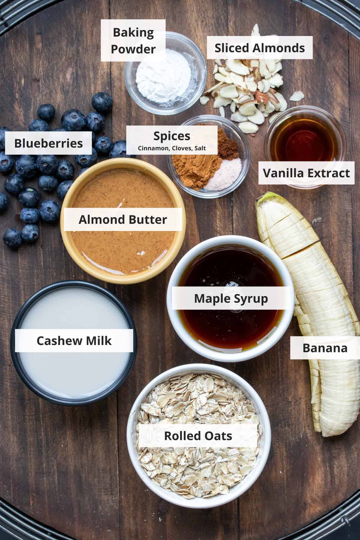 Ingredients for vegan blueberry baked oatmeal on a wood background.