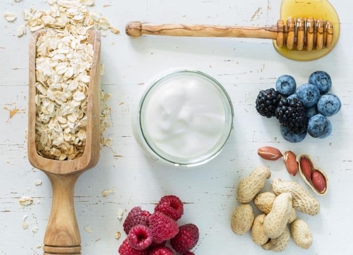 oats, yogurt, honey, berries, and nuts on table