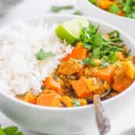 sweet potato and chickpea curry in a white bowl served with rice