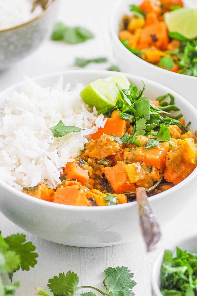 sweet potato and chickpea curry in a white bowl served with rice