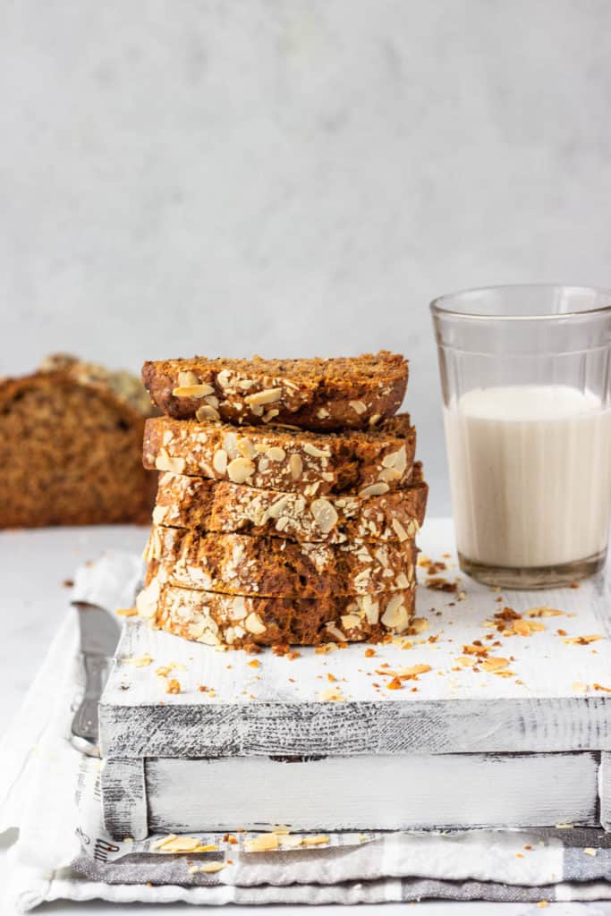 vegan banana bread recipe without butter served on a grey cutting board with a glass of milk