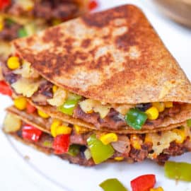 black bean quesadillas with corn and pepper jack cheese on a white plate