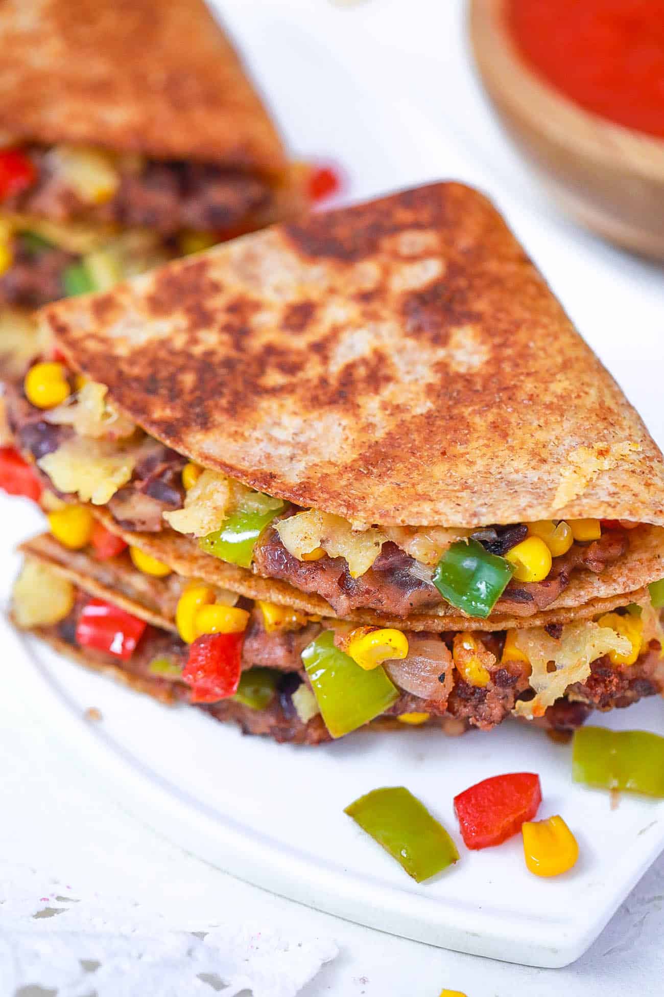 black bean quesadillas with corn and pepper jack cheese on a white plate