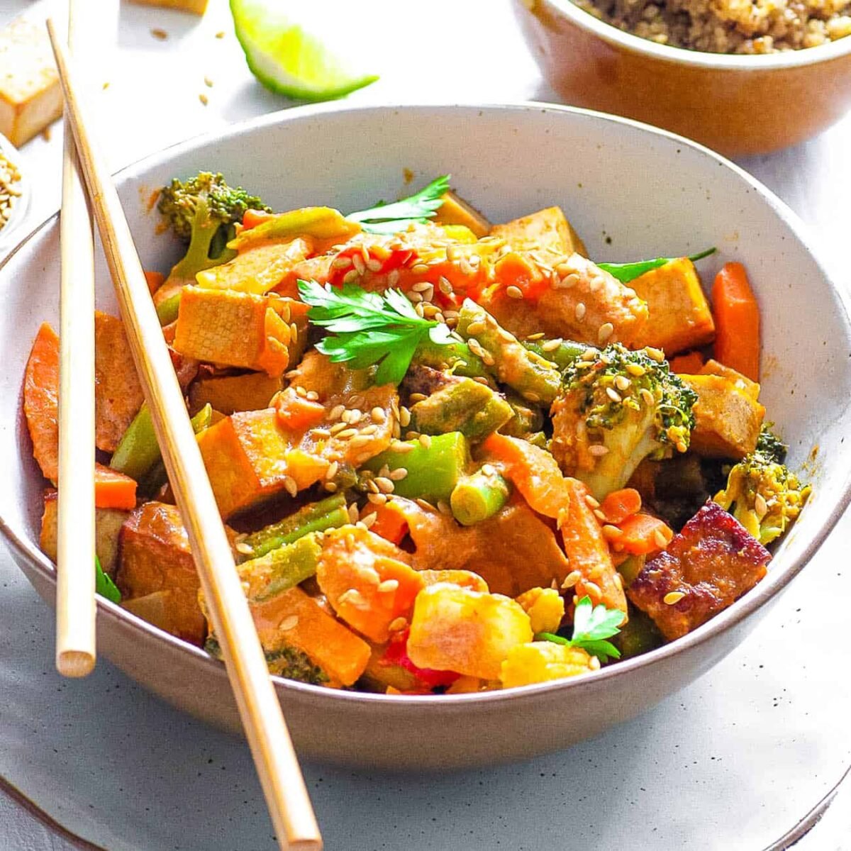 healthy vegetable stir fry recipe served in a white bowl with chopsticks side view