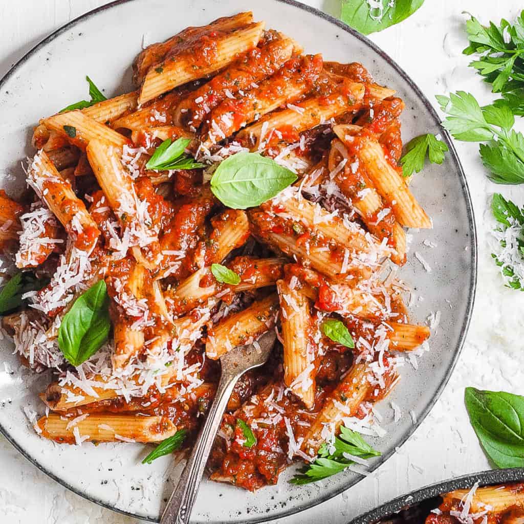 Pasta aus roten Linsen, serviert auf einem weißen Teller mit Superfood-Marinara-Sauce