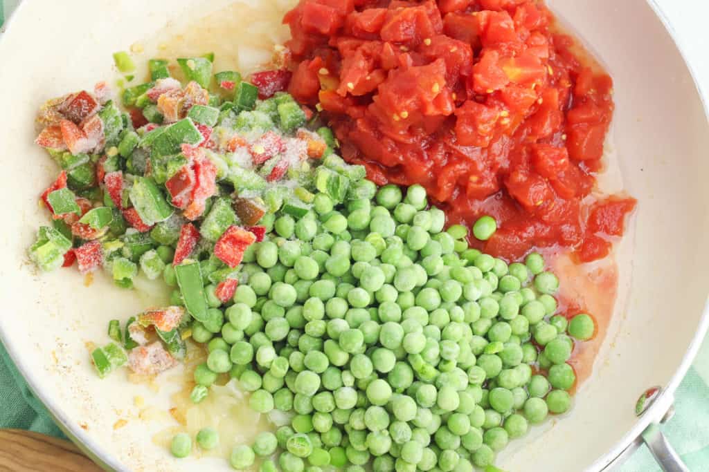 peas and tomatoes added to pan