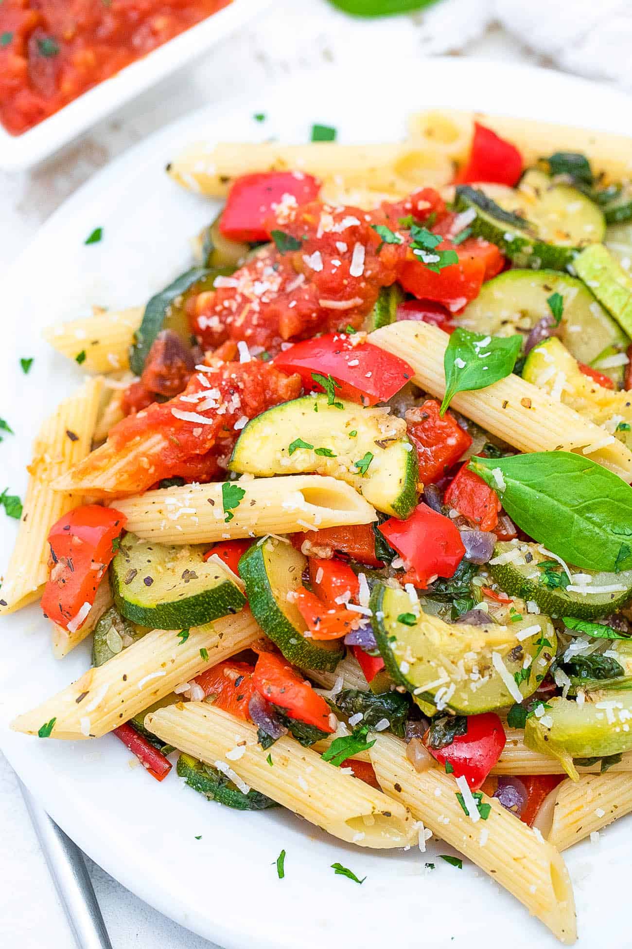 vegan pasta primavera served on a white plate