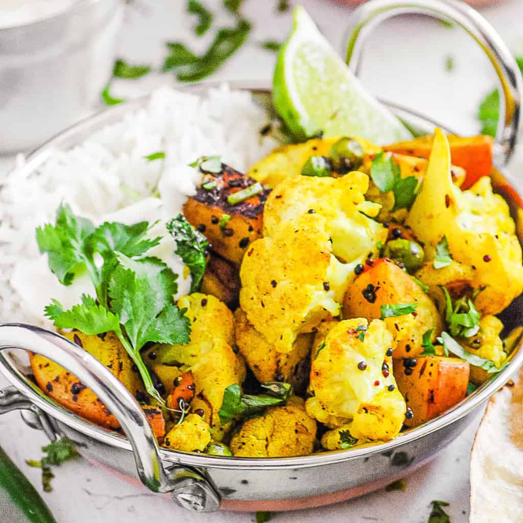 cauliflower sabji in a stainless steel bowl with rice
