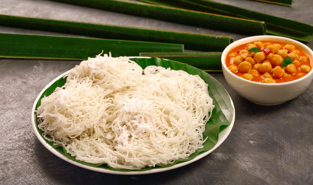 Steamed rice noodles, idiappam with chickpea curry- Vegetarian Kerala foods background.