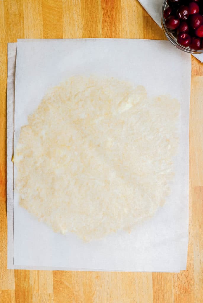 pie dough pressed between parchment paper
