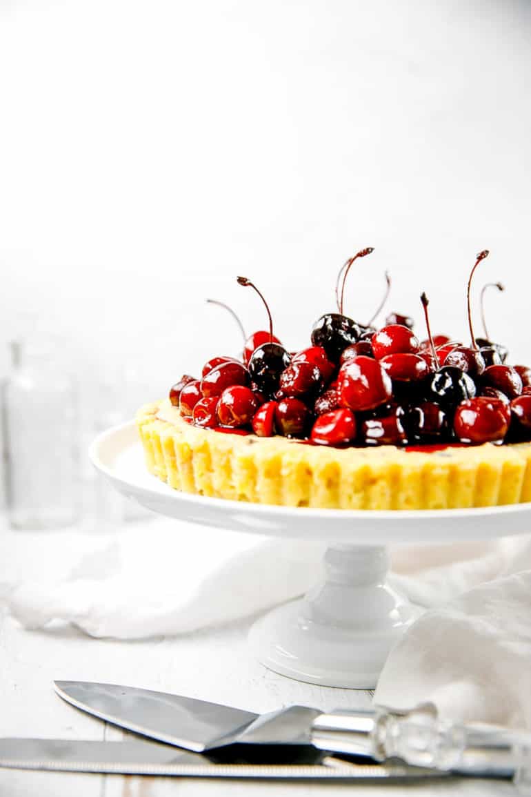 dark chocolate and ricotta pie, finished with fresh cherries, on a cake stand