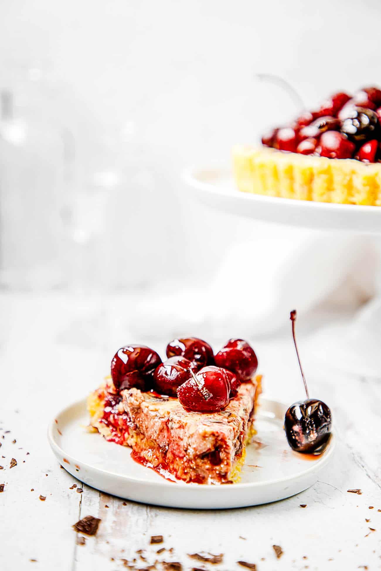 dark chocolate and ricotta pie, finished with fresh cherries, on a cake stand