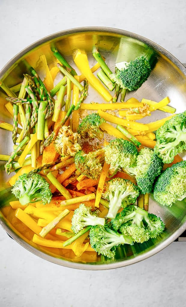 veggies sauteeing in a pan.