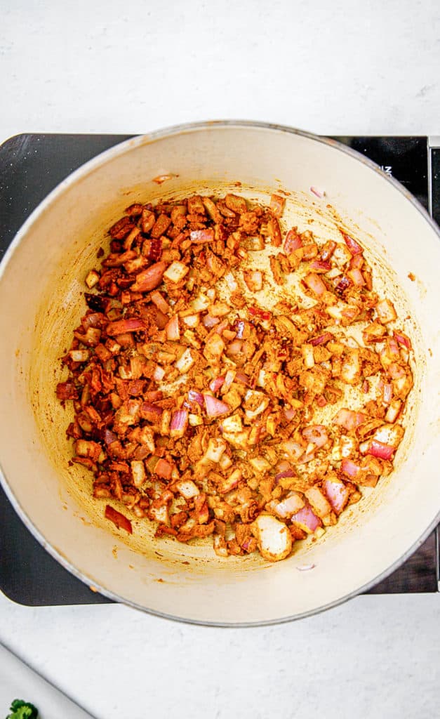 Onions and spices sauteeing in a large pot. 