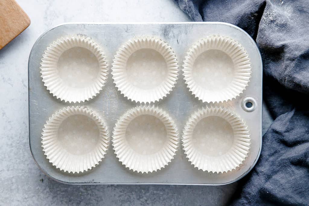 Overhead shot of a muffin tin lined with muffin liners.