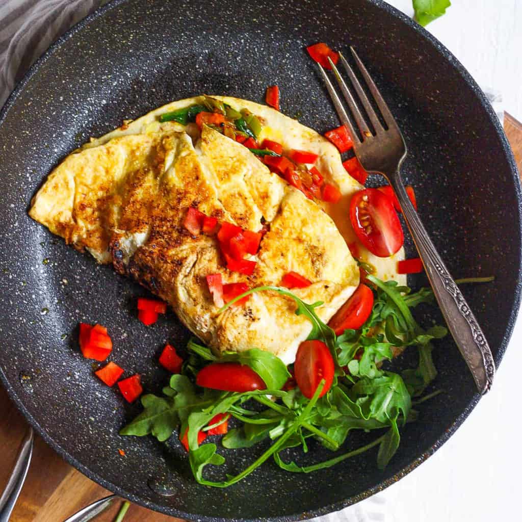 low calorie omelette with indian spices and veggies served on a black plate - healthy omelette