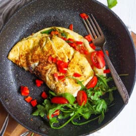 low calorie omelette with indian spices and veggies served on a black plate - healthy omelette