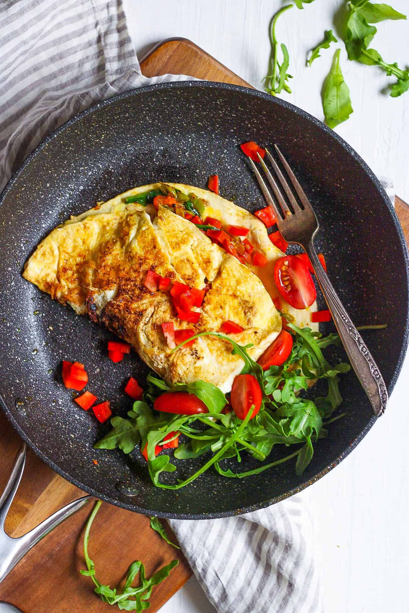 low calorie omelette with indian spices and veggies served on a black plate - healthy omelette