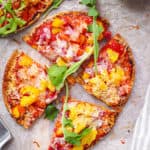 healthy homemade pita pizza / pita bread pizza with veggies as toppings on a cutting board