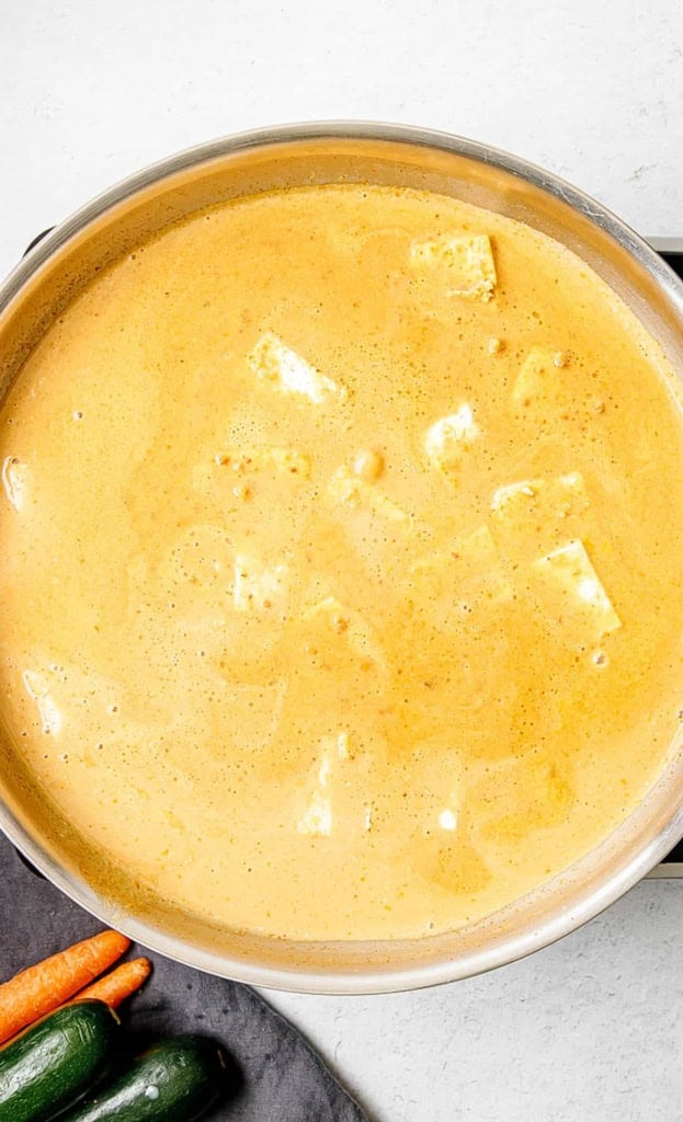 Tofu added to panang curry sauce on the stove.