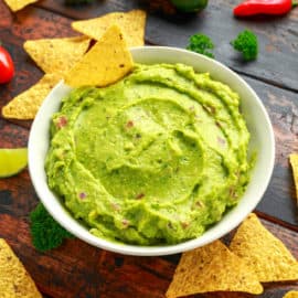 vegan guacamole with tortilla chips in a white bowl