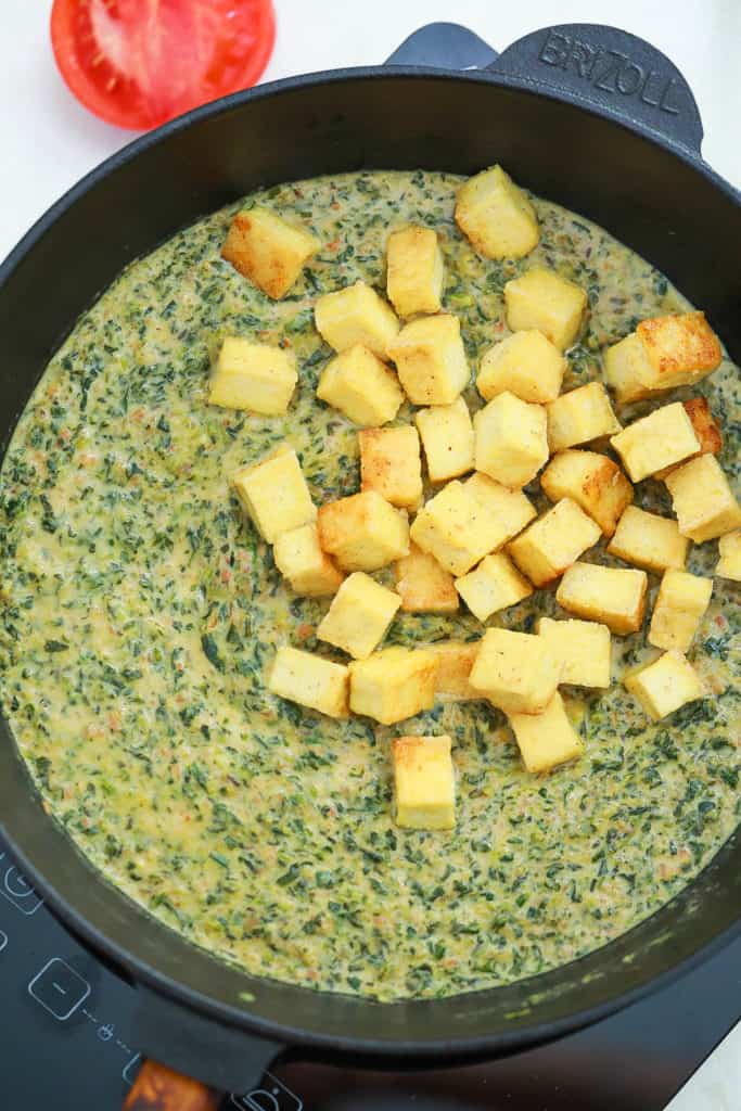 tofu and spinach cooking in a pan