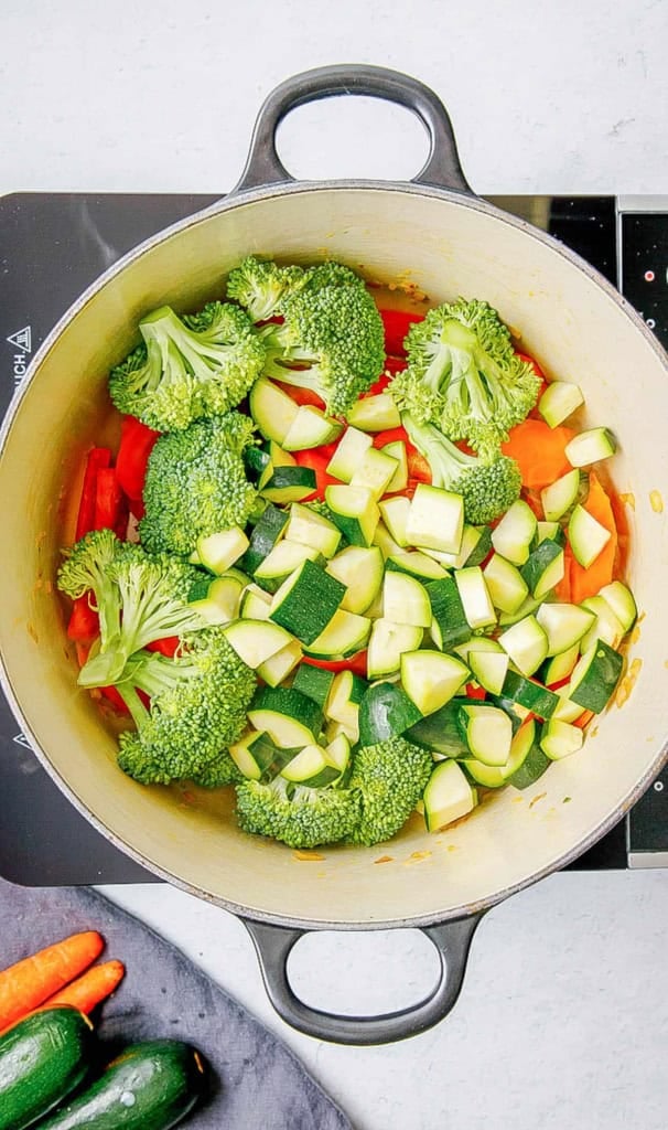 Veggies cooking in a pot on the stove.