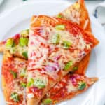 veggie pizza recipe topped with fresh veggies cheese and sauce served on a white plate
