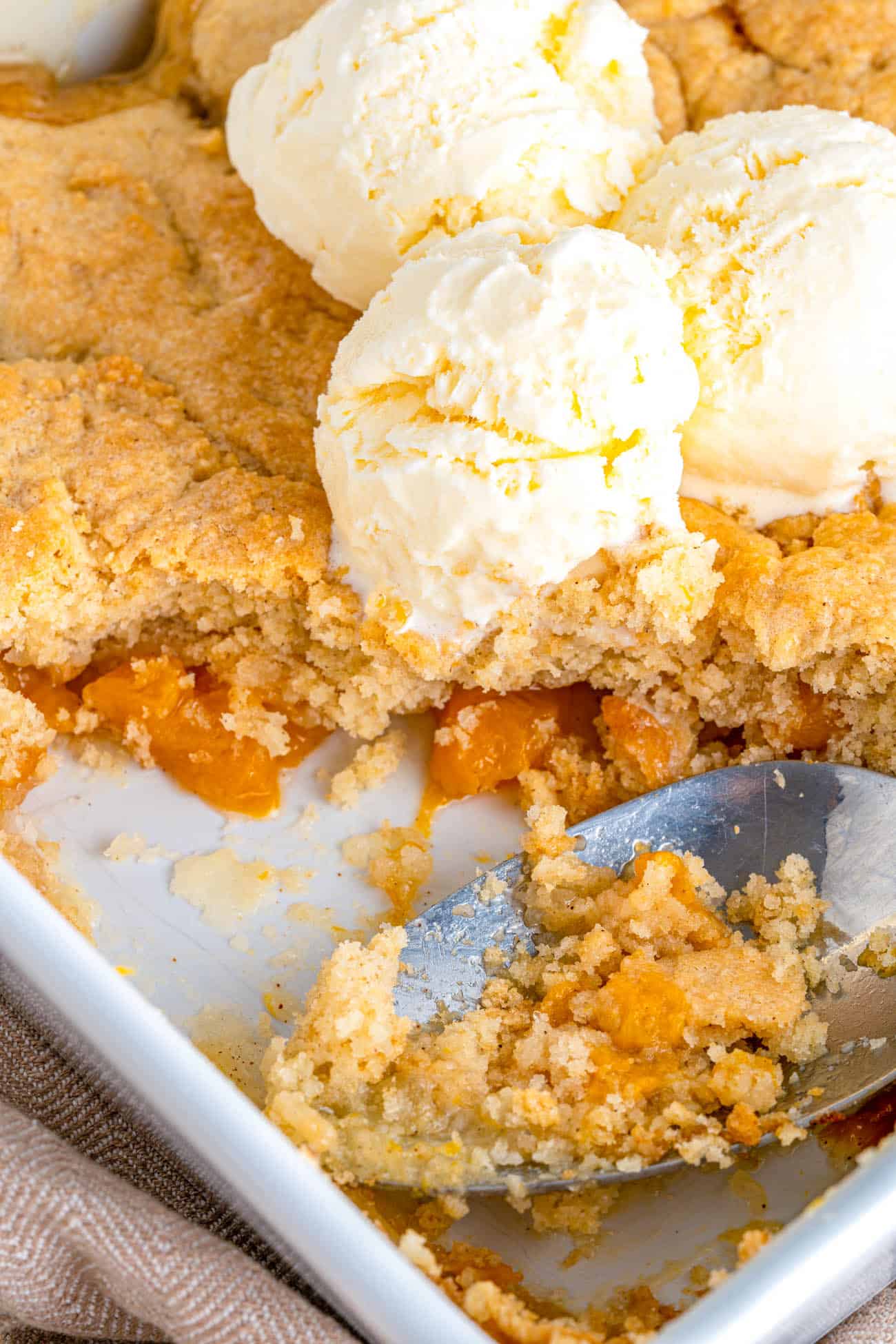 closeup of Vegan Peach Cobbler topped with ice cream