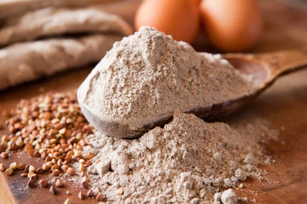 Buckwheat flour in a wooden measuring spoon