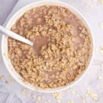 Healthy chocolate oatmeal for picky eaters in a white bowl with a spoon.