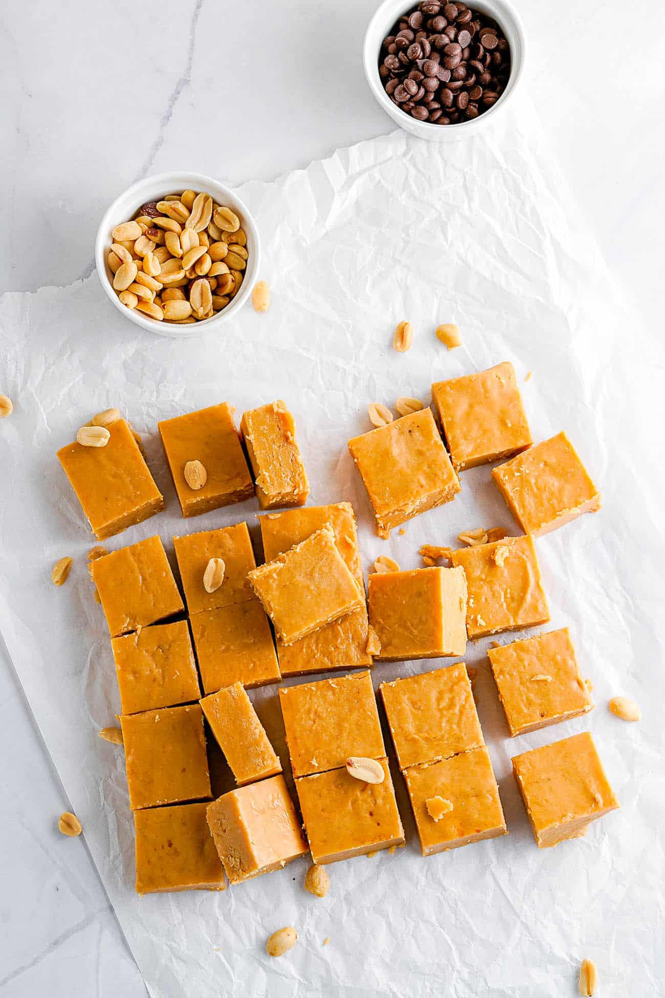 easy microwave peanut butter fudge cut into squares on parchment paper