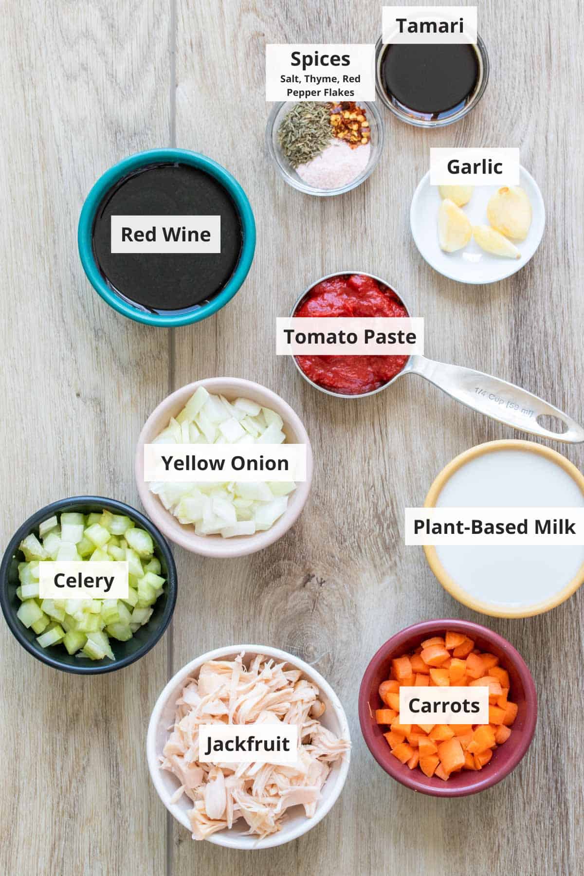 Ingredients for vegetarian bolognese sauce on a wood countertop.