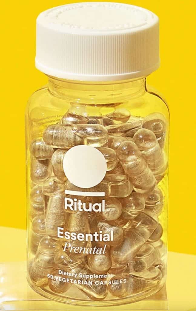 Bottle of Ritual Essential Prenatal Vitamins on yellow backdrop.