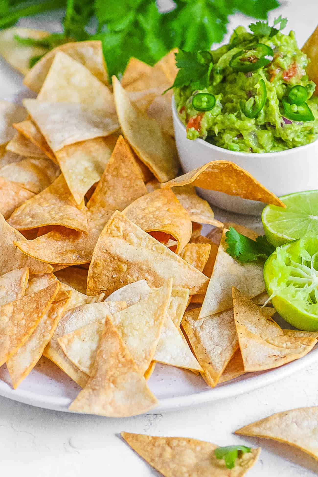 air fryer tortilla chips served with guacamole on a white plate